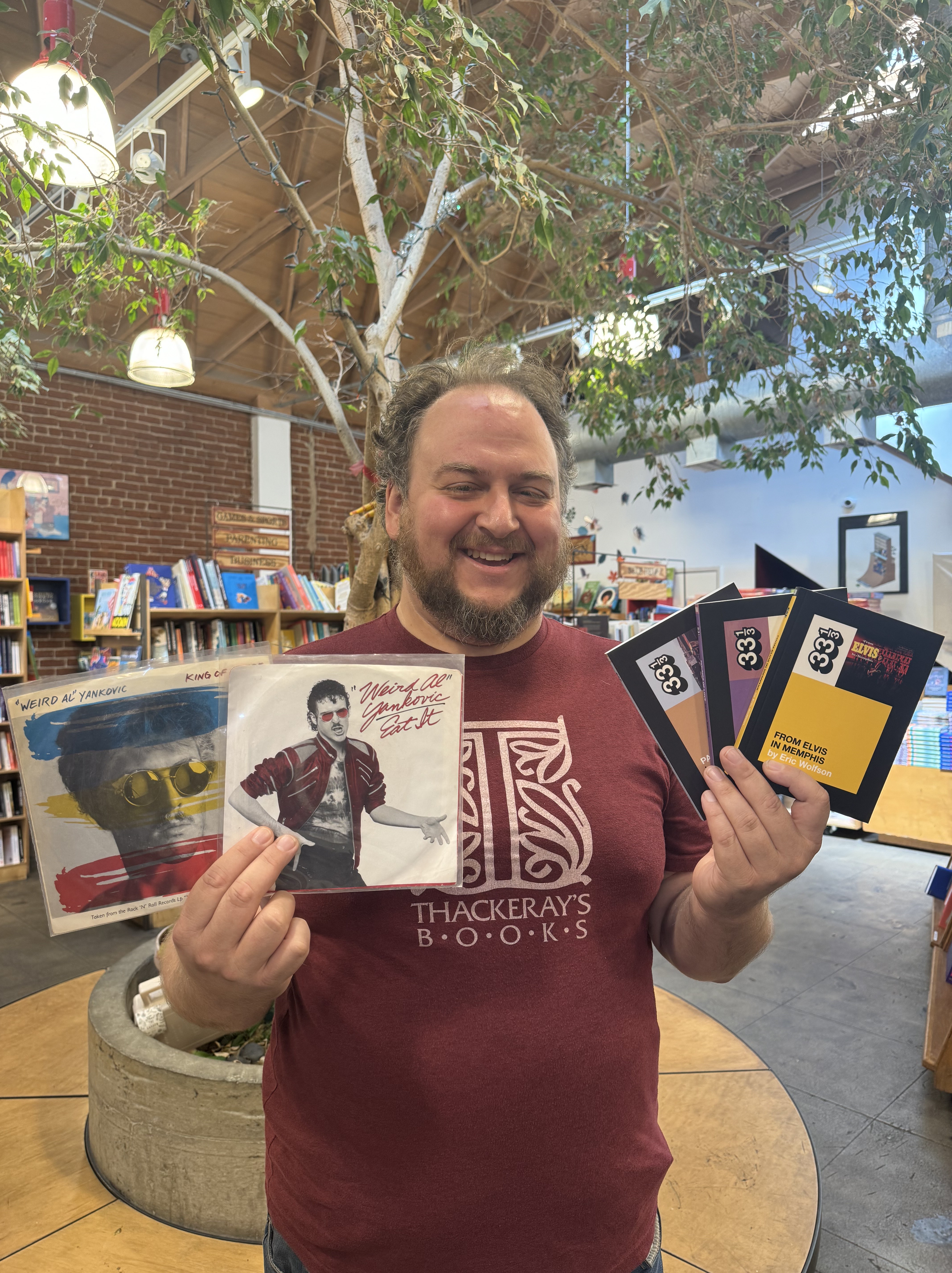 Justin in Bookstore with Weird Al singles and 33 1/3 books